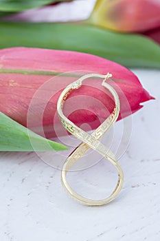 Spring, red tulips and a golden infinity sign on a white background