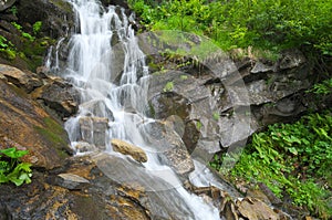 Spring rill flow in mountain photo