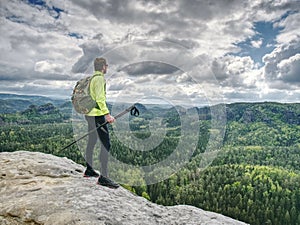 Spring rocky mountains. Hiker with backpack stand on rock