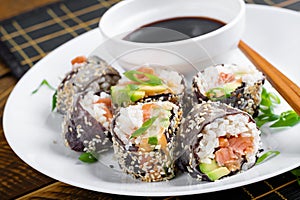 Spring roll with nori, sushi rice, salmon, cucumber and avocado, sriracha