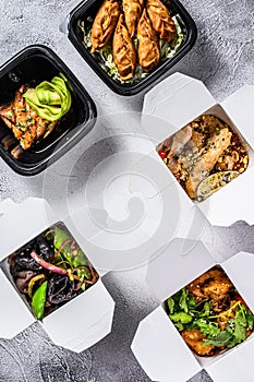 Spring rolls, dumplings, gyoza and wok noodles in Take away box. Healthy lunch. Take and go organic food. White background. Top