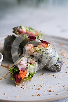 Spring rolls with vegetables and shrimp on white plate