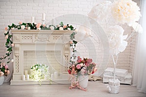 Spring romantic decoration with a fireplace, large paper and artificial flowers