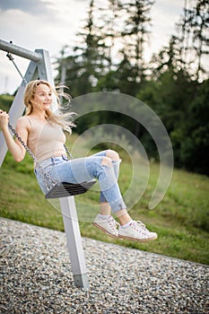 Spring romantic woman swinging on swing