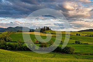 Spring rural landscape with dramatic sky at sunset