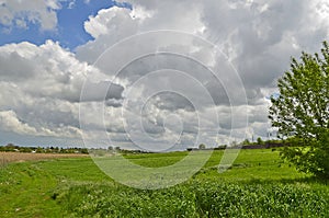 Spring rural landscapes, fields, clouds, village.