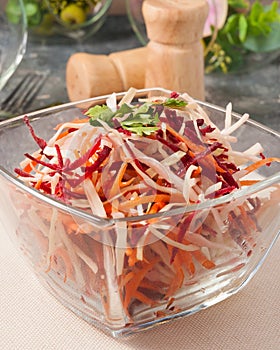 Spring salad with cabbage beetroot carrot in a glass bowl