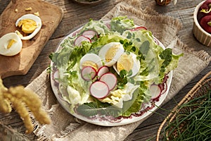 Spring salad with eggs, radishes and wild edible plants - chickweed, nipplewort and yarrow