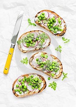 Spring sandwiches - grilled bread, cream cheese, green peas, radishes and micro greens. Healthy eating, slimming, diet lifestyle c