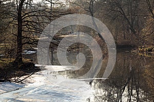 In the spring, when the snow had not yet melted, trees were reflected in the reservoir