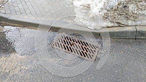 In spring, snow melts on city streets and meltwater flows down the paving slabs and asphalt into the storm sewer. The sewer well i