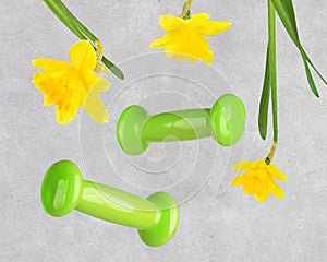 Spring sports background with dumbbells and flowers levitation.