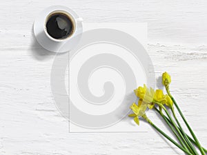 Spring styled stock photo. Feminine mock-up with daffodil flowers, Narcissus, list of paper, and cup of coffee. Shabby