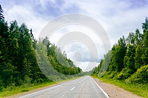 Road in green forest scenery lanscape with blue sky