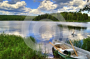 Spring summer landscape blue sky clouds river boat green trees in Sweden