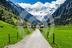 Spring summer mountains landscape with alpine village and snowy peaks in the background. Stillup, Austria, Tirol