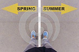 Spring and summer text arrows on asphalt ground, feet and shoes