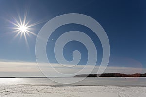 The spring sun in the afternoon over the lake covered with ice