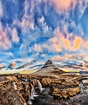 Spring sunrise over the famous Kirkjufellsfoss Waterfall with Kirkjufell mountain in the background in Iceland