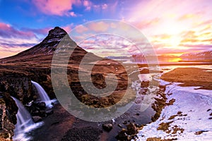 Spring sunrise over the famous Kirkjufellsfoss Waterfall with Kirkjufell mountain in the background in Iceland