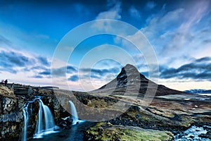 Spring sunrise over the famous Kirkjufellsfoss Waterfall with Kirkjufell mountain in the background in Iceland