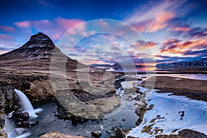 Spring sunrise over the famous Kirkjufellsfoss Waterfall with Kirkjufell mountain in the background in Iceland