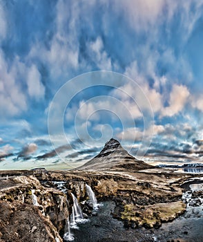 Spring sunrise over the famous Kirkjufellsfoss Waterfall with Kirkjufell mountain in the background in Iceland