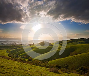 Spring sunset over green hills