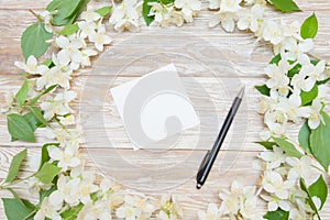 Spring tender background with card, pen and white flowers. Blank