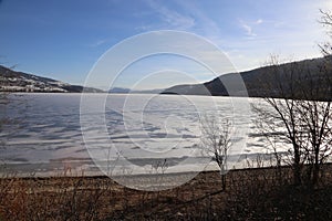 Spring and thawing lake -ice on the lakefront- a frozen lake slowly thawing out to end winter and start spring!