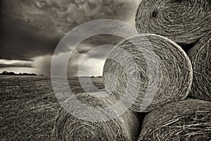 Spring Thunderstorm Approaches Hay Bales in Black and White Sepia photo