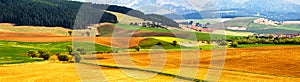 Spring tillage on hills panorama. Picturesque ploughland