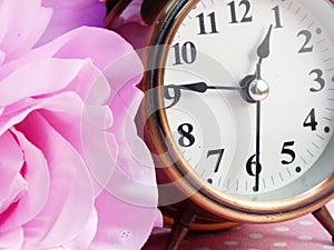 Spring time with alarm clock and artificial flowers bouquet background