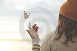 Spring time, a butterfly leans delicately on a woman`s hand photo