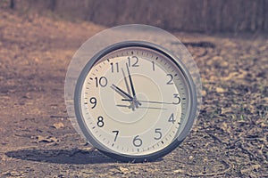 Spring Time Change. Summer back concept. Vintage alarm Clock outdoors