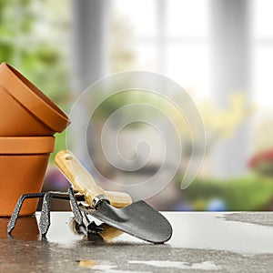 Spring time in the garden. Gardening tools equipment with blurred idyllic rural picture background outside the window.