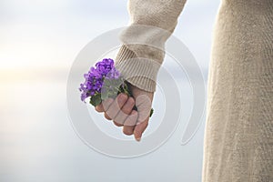 Spring time, woman holds a bouquet of colorful flowers in her hand