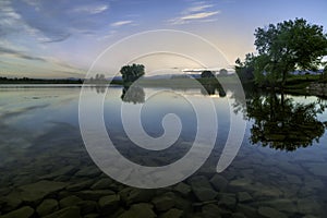 Spring Trees reflecting in the Colorado Lake at sunrise