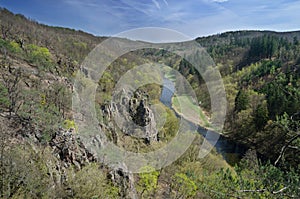 Spring valley landscape with river, rock cliffs and forests