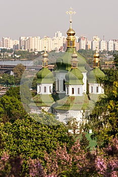 Spring view of Vydubychi Monastery and Dnipro river with lilac blossom in botanical garden in Kyiv, Ukraine