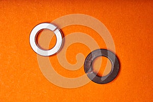 Spring washers on orange background. Bolted connection elements