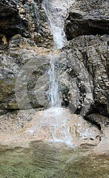 spring water that flows from the rock forming a waterfall