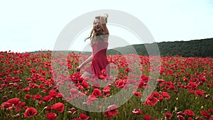 Spring woman. Attractive girl in flowers poppy feild. Freedom on nature. Young woman on Spring meadow. Lovely young