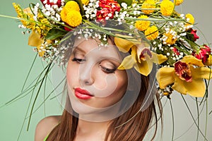 Spring Woman. Beauty Summer model girl with colorful flowers wreath and colorful hair. Flowers Hair Style.