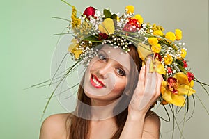 Spring Woman. Beauty Summer model girl with colorful flowers wreath. Flowers Hair Style.