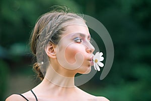 Spring woman with daisy flower in mouth. Beauty, nature concept. Fashion look, makeup. Youth, flowering, blossom, bloom.