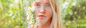 Spring woman face for banner. Beautiful woman portrait close up. Woman on background with flowers on a spring day.