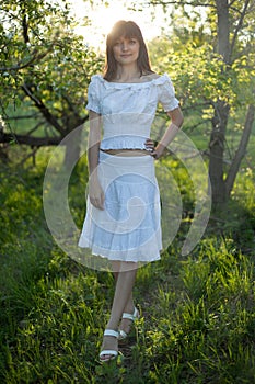 Spring - Woman under blossom tree enjoy sun . Beautiful nature at sunset in the evening