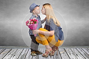 Small son gives his beloved mother a beautiful bouquet of pink roses and kisses mum . Spring,Women`s day,mother`s day.