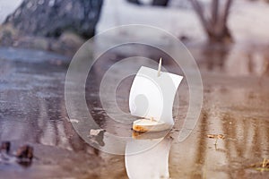 Spring. A wooden boat with a sail swims along a forest puddle. Toning